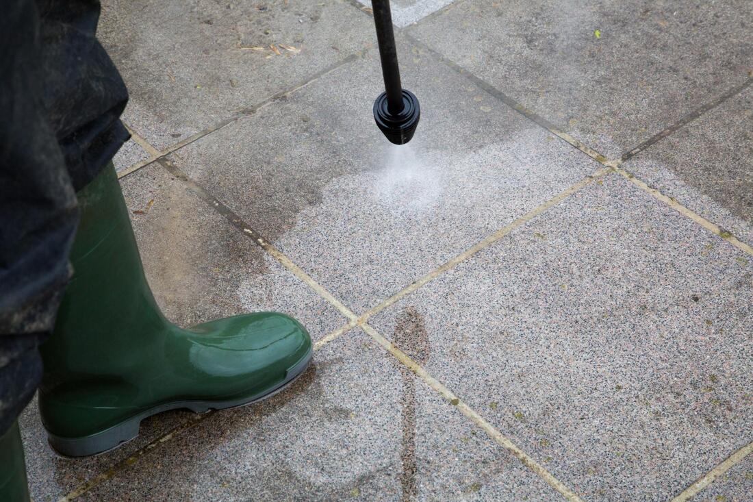 cleaning the floor using pressure washer